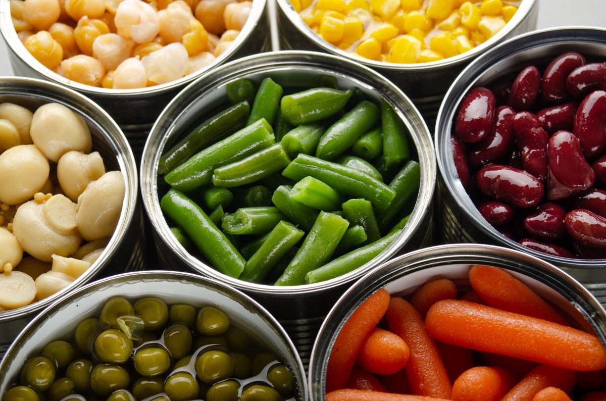 Ist Dosengemüse ungesund: mehrere Konservendosen mit Gemüse und anderen Lebensmitteln in der Draufsicht.