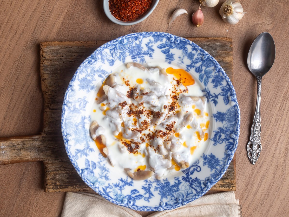 türkische Pasta mit Hackfleisch auf einem blau gemusterten Teller mit Joghurtsoße und Paprika-Butter