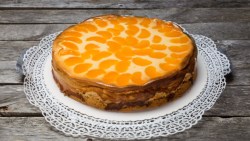 Ein Faule-Weiber-Kuchen mit Mandarinen auf einer Kuchenplatte.