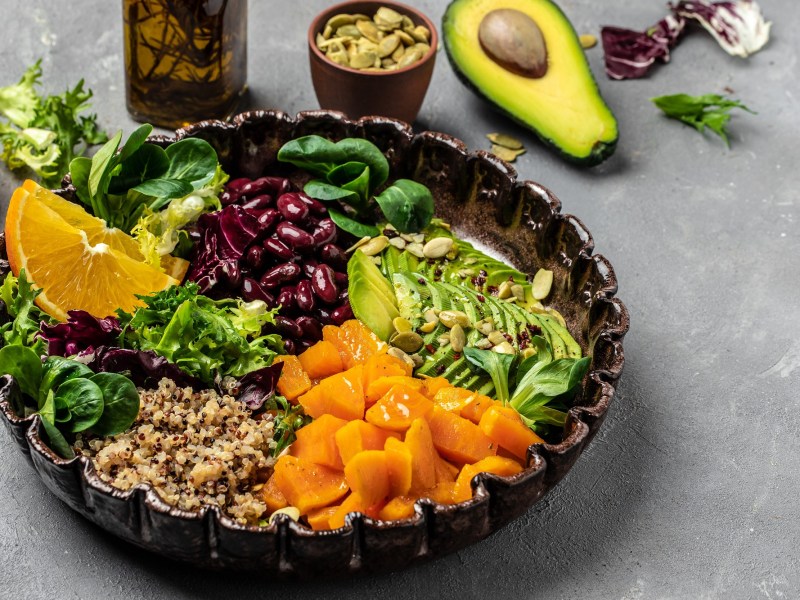 Fitnessbowl mit Quinoa, Süßkartoffeln, Avocado, Salat und Bohnen.