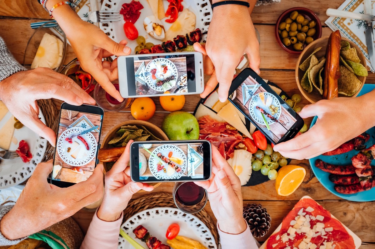 Gruppe junger Menschen an einem Tisch mit Essen fotografiert ihr essen von oben