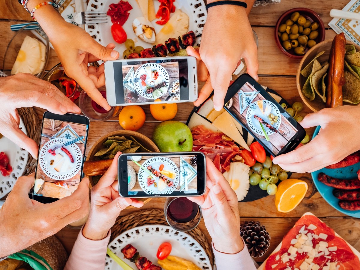 Gruppe junger Menschen an einem Tisch mit Essen fotografiert ihr essen von oben