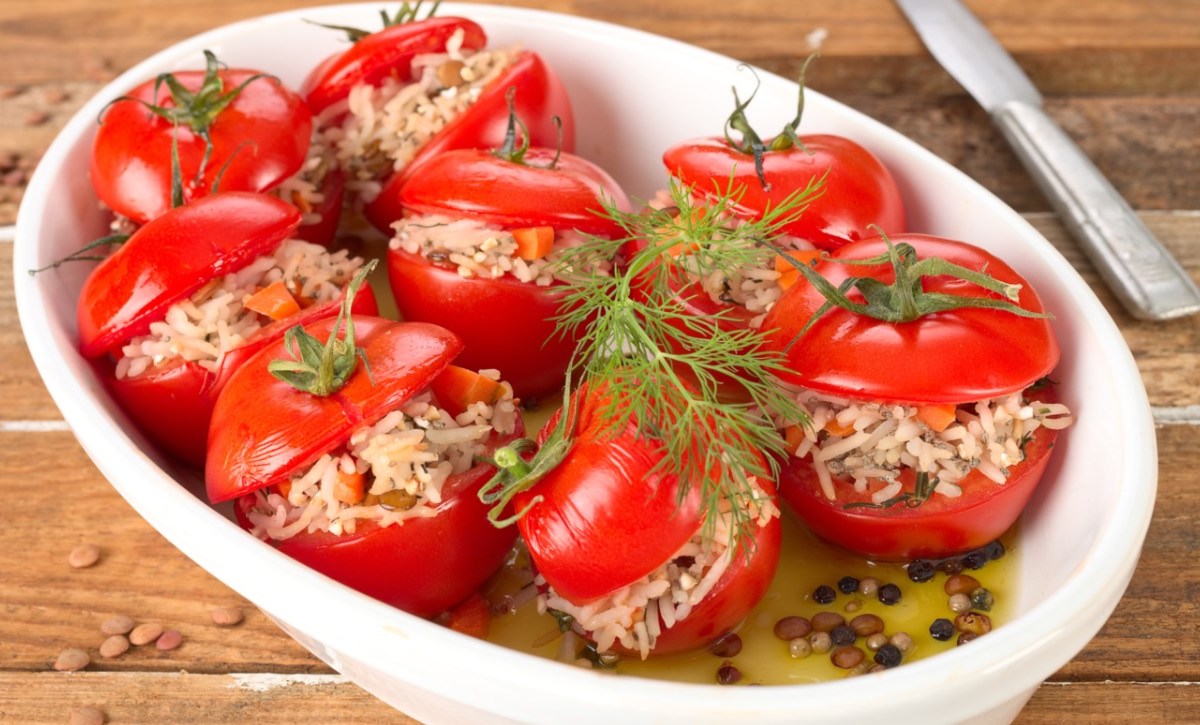 Mehrere gefüllte Tomaten in einer Auflaufform.