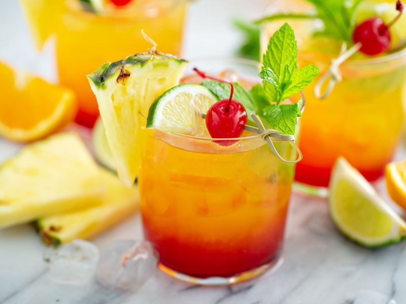 Limoncello Sunrise, serviert in einem hübschen Glas mit frischen Früchten als Deko.