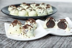 Weißer Teller mit Oreo-Pralinen und einem dunklen Teller Pralinen im Hintergrund