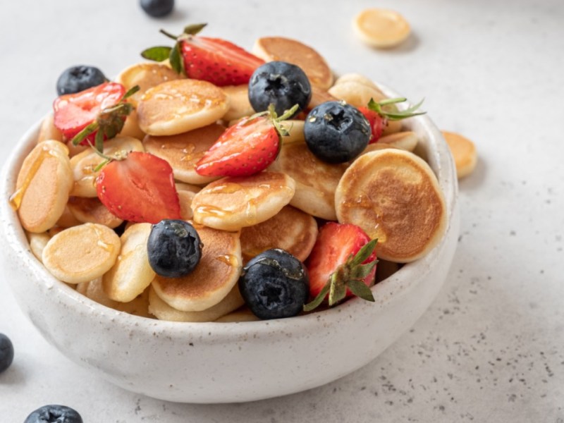 Eine Schüssel Pancake Cereal mit Erdbeeren und Blaubeeren.