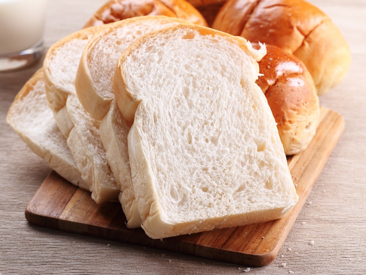 Toastbrot selber machen: ein in Scheiben geschnittenes Toastbrot auf einem Brett, daneben noch ein ganzes Brot.