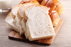Toastbrot selber machen: ein in Scheiben geschnittenes Toastbrot auf einem Brett, daneben noch ein ganzes Brot.