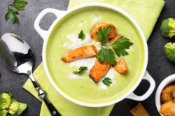 Eine Schüssel Brokkolisuppe mit Lachs in der Draufsicht.