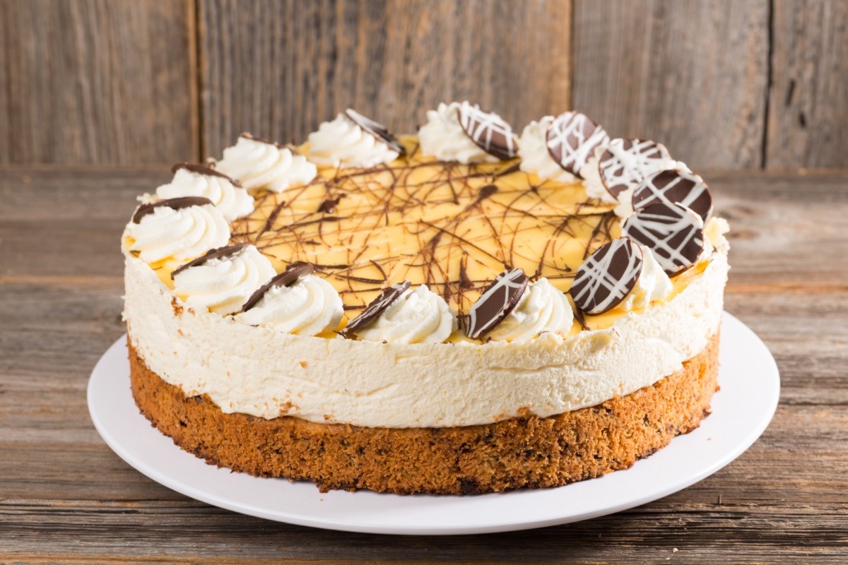 Eine Eierlikörtorte mit Schokoladenverzierung auf einer flachen Tortenplatte.
