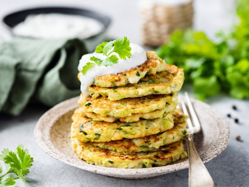 Ein Turm aus Kartoffel-Pancakes mit Dip auf einem Teller