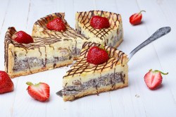 4 Stücke Mohnkuchen mit Eierlikör und Schmand, mit Erdbeeren und Schokosoße verziert.