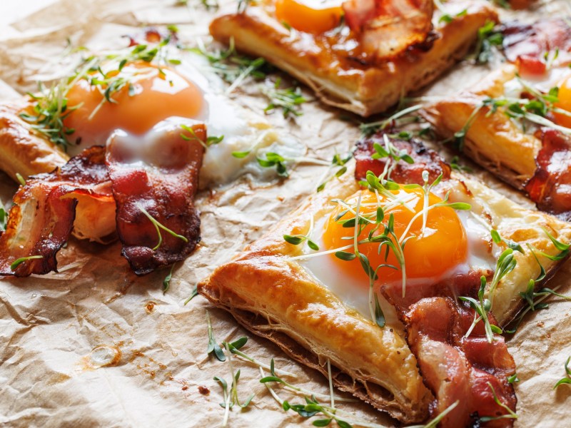 In Stücke geschnittene Blätterteig-Tarte mit Ei und Schinken.