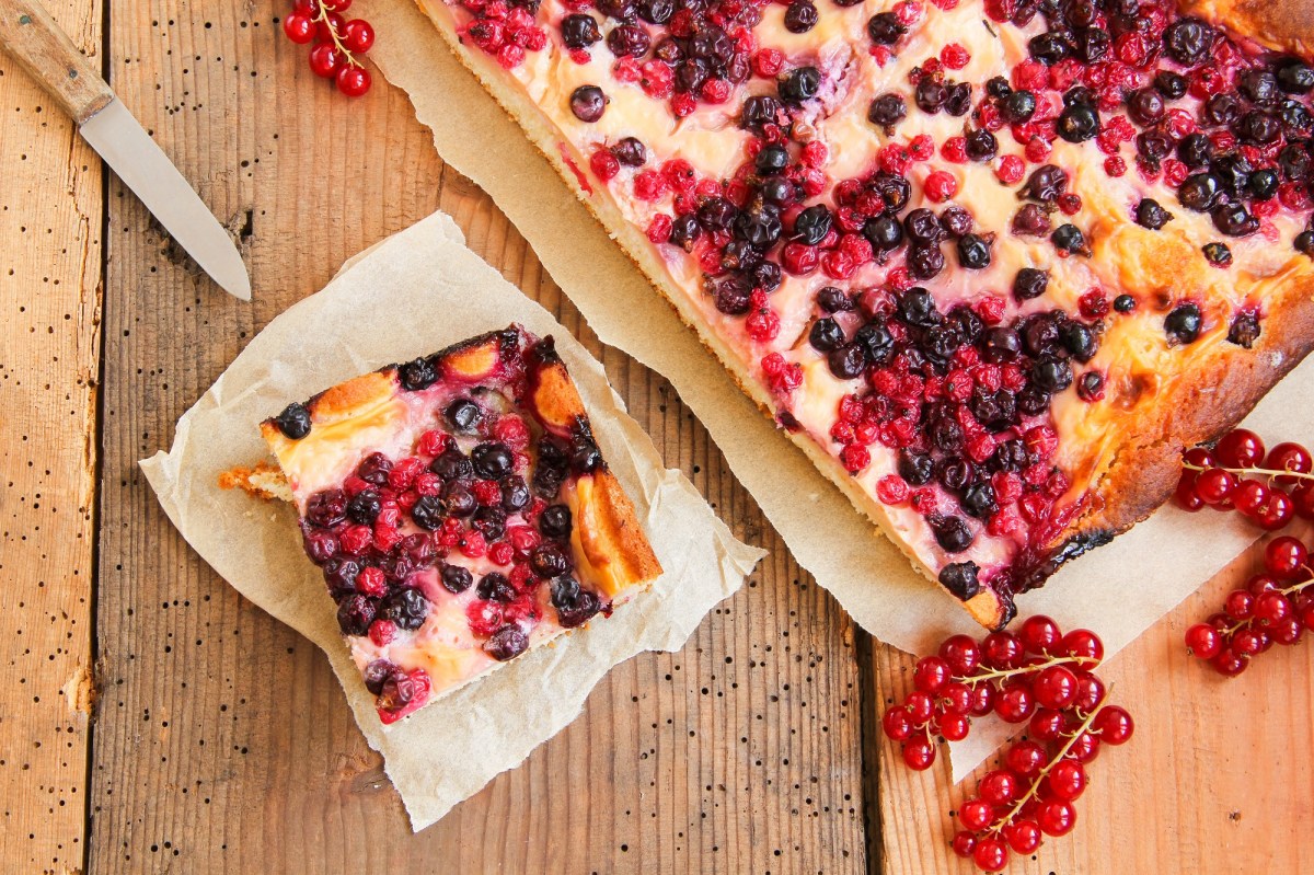 Buttermilchkuchen mit Beeren auf einem Holztisch