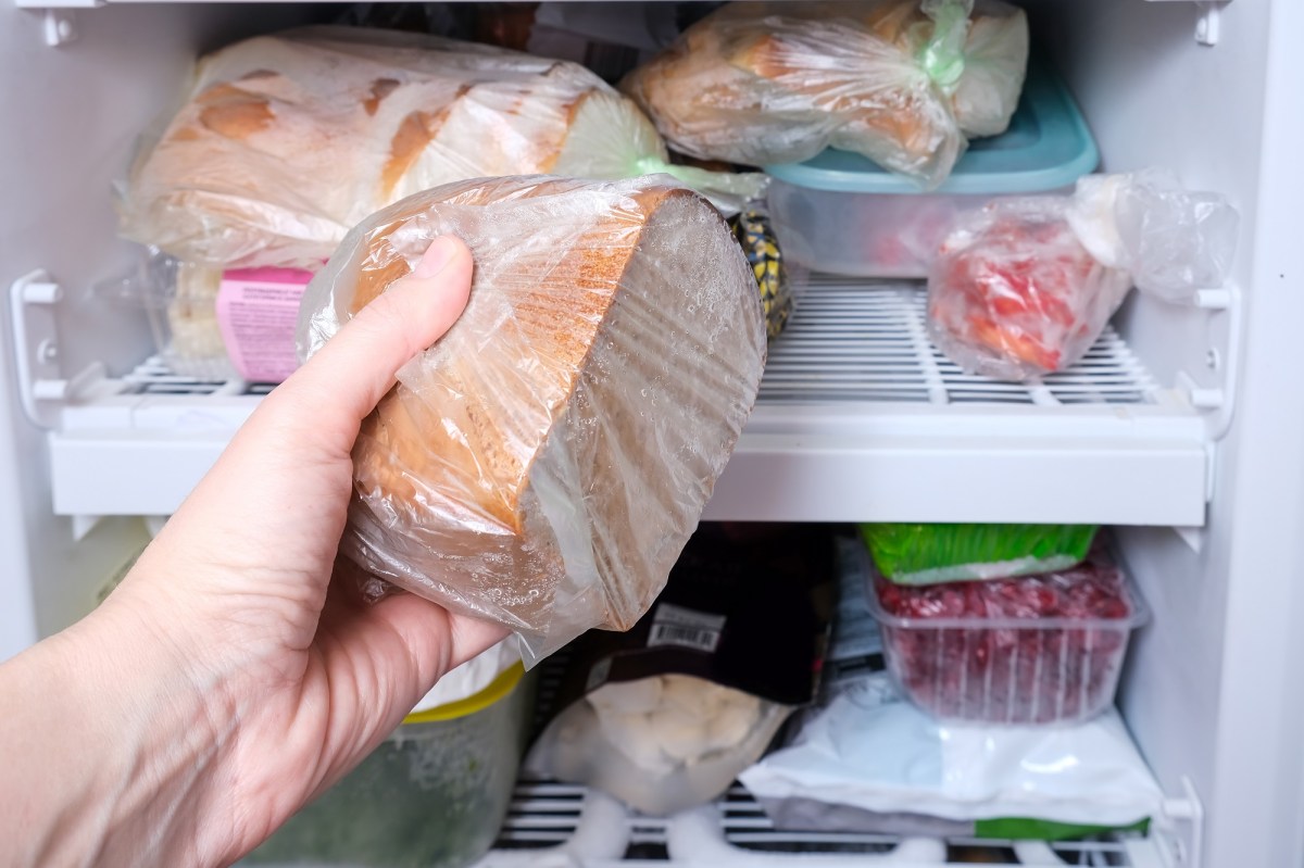 Brot einfrieren: Eine Hand legt ein eingepacktes Brot ins Gefrierfach