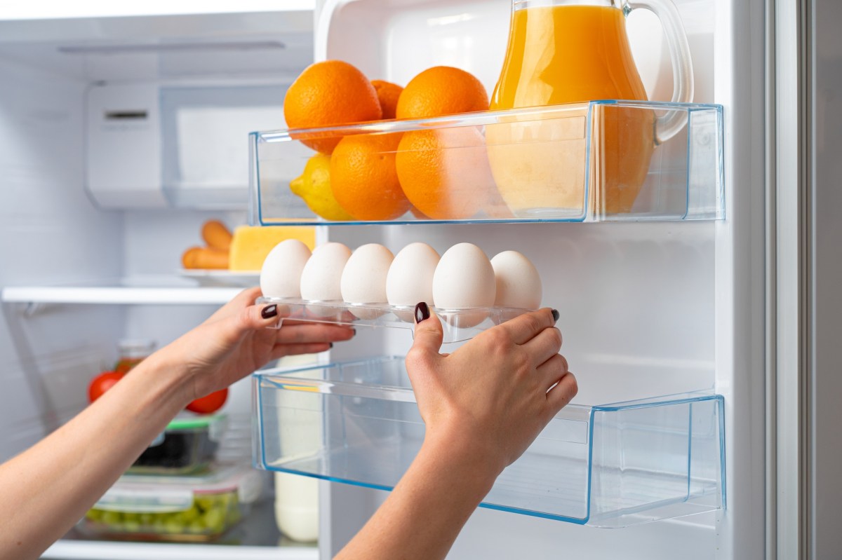 Frau holt frische Eier aus dem Kühlschrank