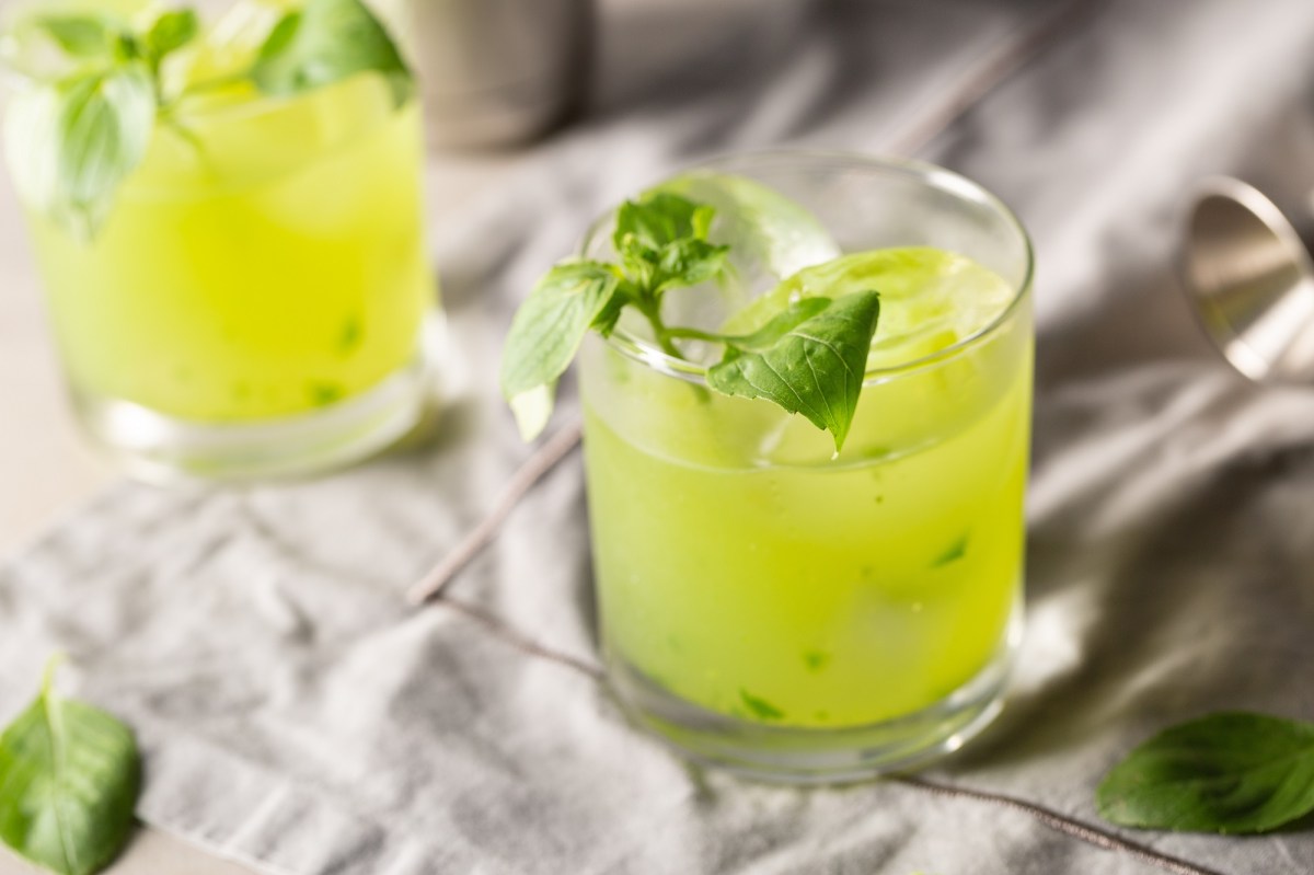 Zwei Gläser Gin Basil Smash auf grauem Untergrund