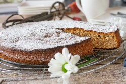 Abkühlgitter mit mallorquinischem Mandelkuchen und einer Blume im Vordergrund.