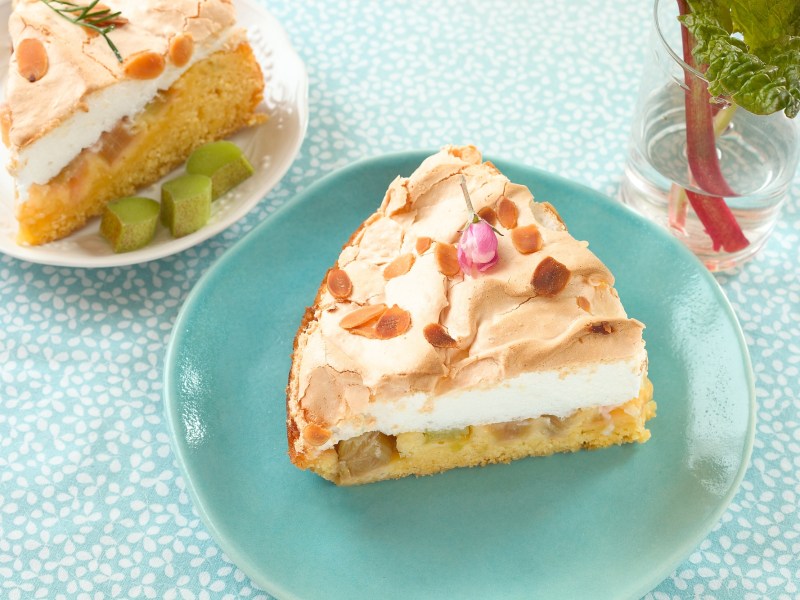 Ein Stück Schneemousse-Torte mit Rhabarber auf einem blauen Teller