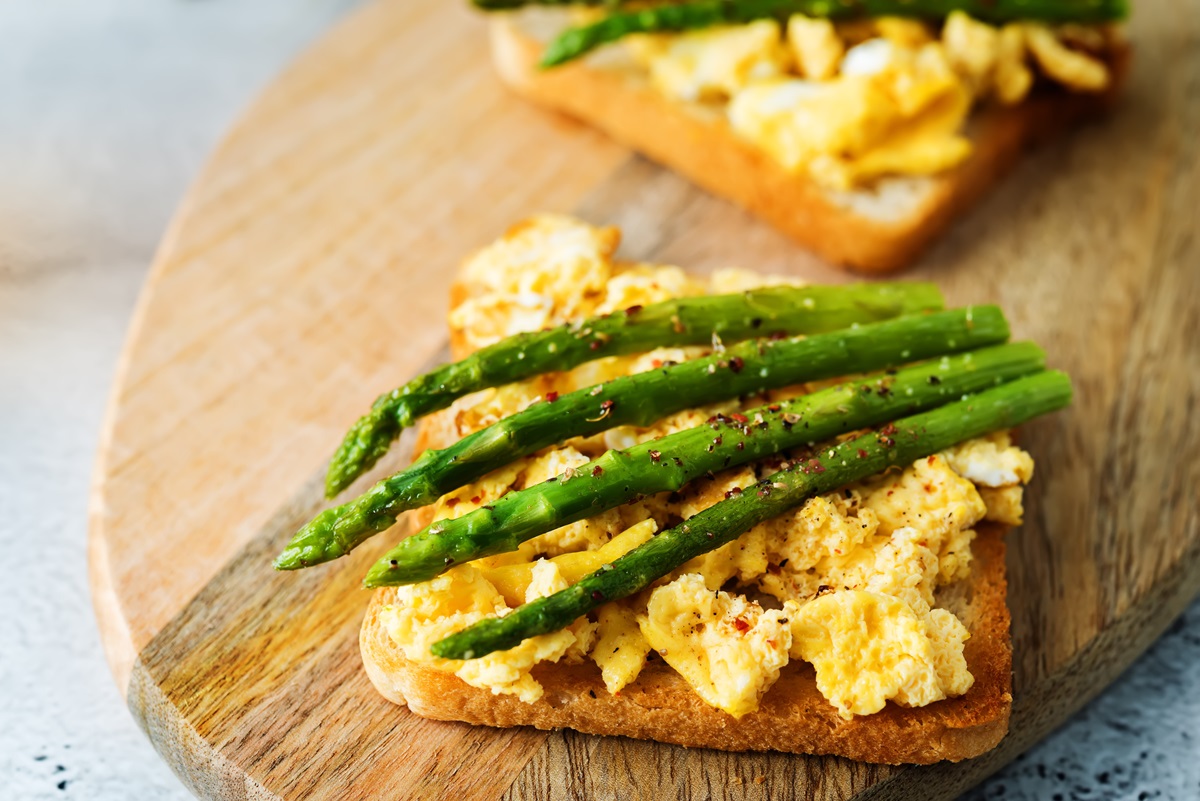 Spargel-Toast mit Rührei auf einem Holzbrett