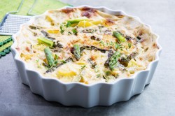 Auflaufform mit Spargel-Auflauf mit Kartoffeln auf hellem Tisch