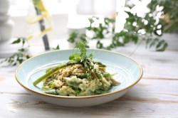 Spargelrisotto mit Spinat und Erbsen, garniert mit Microgreens.