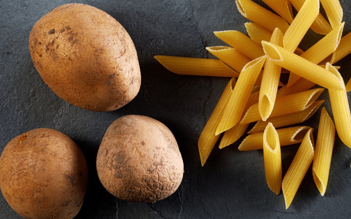 Was ist gesünder, Kartoffeln oder Nudeln: rohe Nudeln liegen neben rohen Kartoffeln.