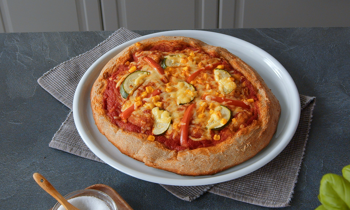 Teller mit Pizza aus Vollkorn-Pizzateig