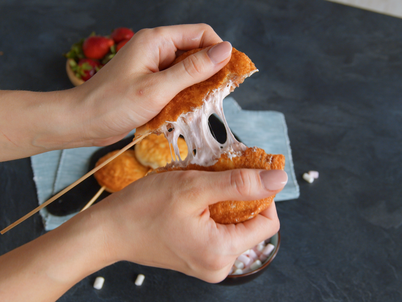 Ein Toast-Pop wird von zwei Händen auseinander gezogen und offenbart seine leckere Füllung.