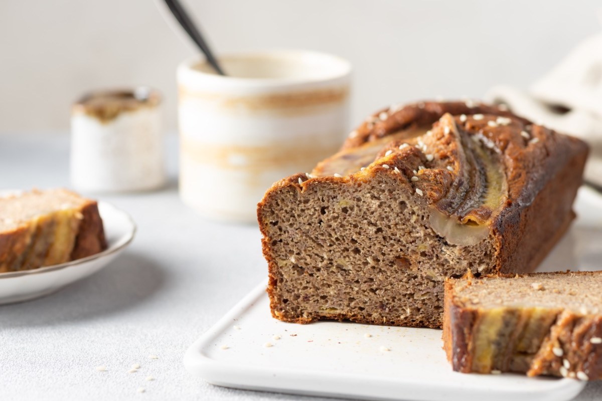 Ein aufgeschnittenes Tahini-Bananenbrot auf einem Brett.
