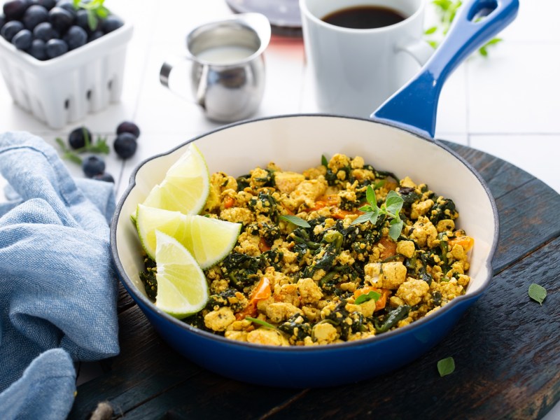 Rührtofu in einer blauen Pfanne, garniert mit Zitrone.