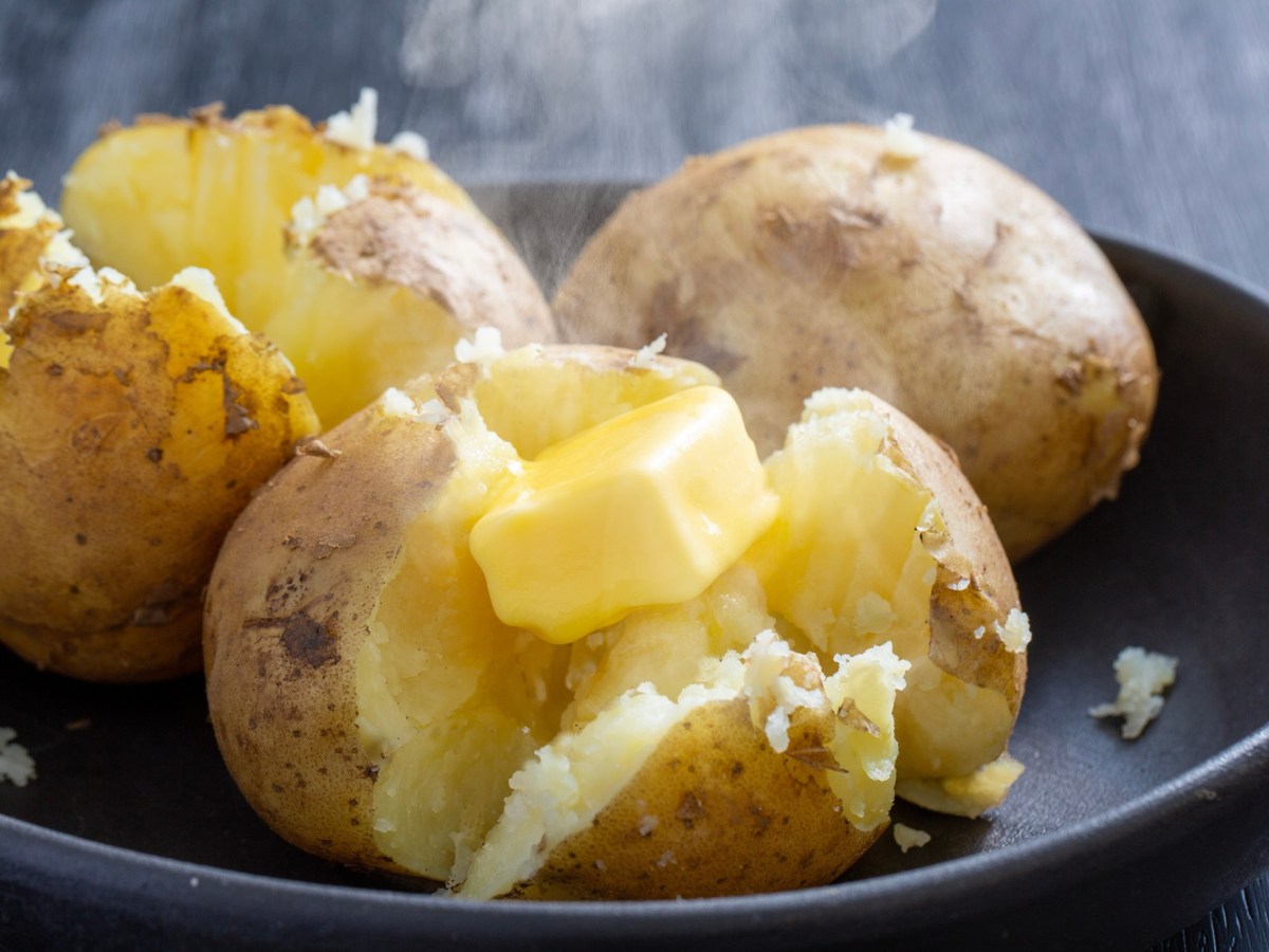 Mehligkochende Kartoffeln nach dem Kochen, aufgeschnitten und mit Butter garniert.