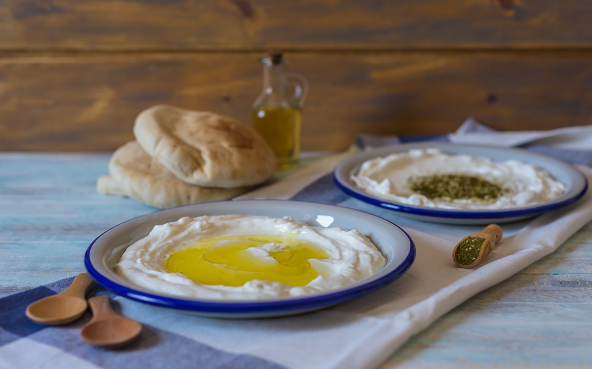 Labneh selbst machen: zwei Teller Labneh stehen nebeneinander, einer ist mit Olivenöl beträufelt.