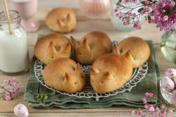 Osterhasen-Zitronenbrötchen auf einem Kuchengitter, drumherum Osterdeko.