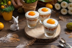 Drei Gläser mit Spiegelei-Dessert auf einem Tisch, Osterdeko daneben