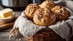 Korb mit Haferflocken-Quark-Brötchen aus dem Airfryer, Butter daneben
