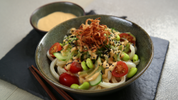 Eine Schale kalter Udon mit Sesamsoße auf einer Schieferplatte.
