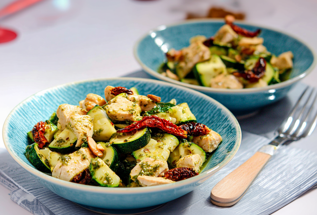 Zucchini-Hähnchen-Salat, serviert in zwei Schalen. Daneben liegt eine Gabel.